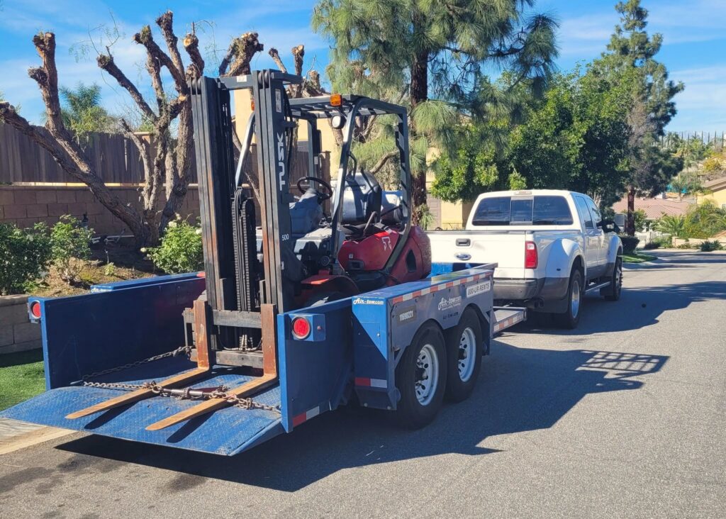 forklift loaded and strapped onto an Air-tow trailer